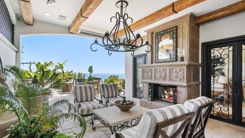 Ocean-view covered lounge with fireplace at The Beach Cottage at Seasons in Malibu