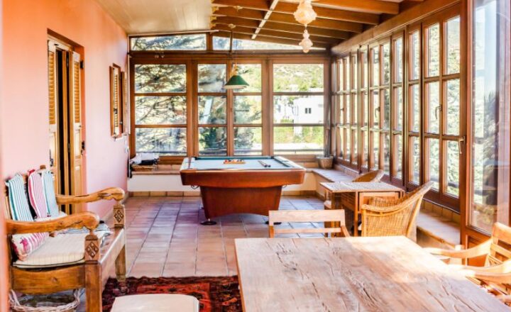 Wood-furnished sunroom with billiards table at the Go Green Project X residential retreat in Nea Penteli