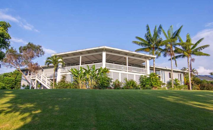 Hawaii Island Recovery residence with covered lanai, palm trees and lawn in Kailua-Kona