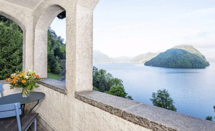 Covered hotel terrace used by NEOVIVA guests, with seating and a view over Lake Lucerne