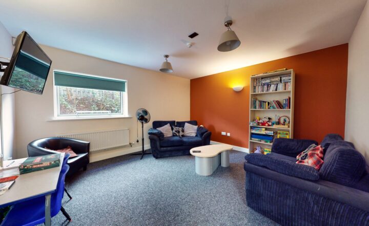 Communal lounge with blue sofas at Oasis Bradford