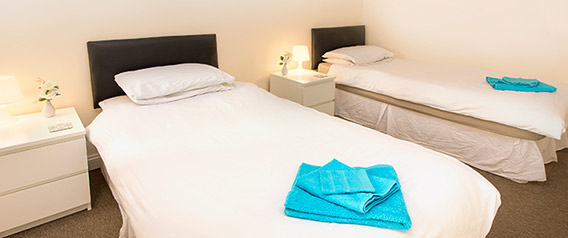Shared bedroom with two beds at Oasis Runcorn