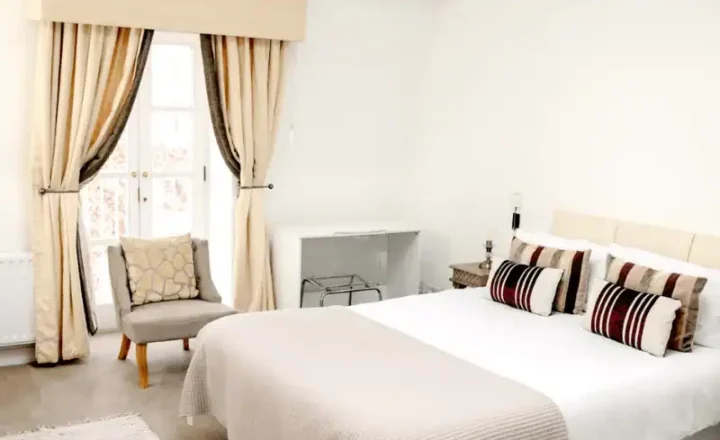 Private bedroom with a double bed, bedside tables and armchair at PROMIS Kendrick Mews