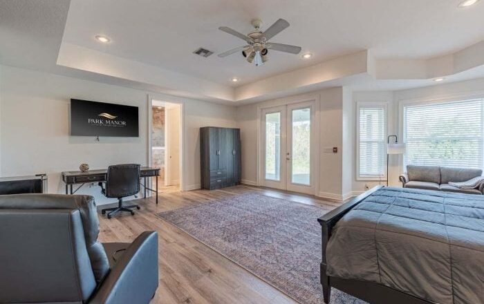 Private bedroom at Park Manor Recovery in Avon Park, with a bed, desk and seating