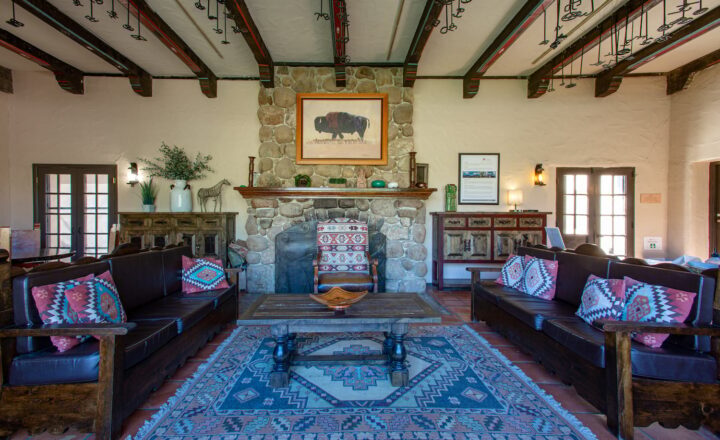 Southwestern-style communal lounge with a stone fireplace at Sabino Recovery