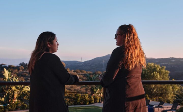 Two people talking on a terrace overlooking the grounds at San Diego Detox and Residential