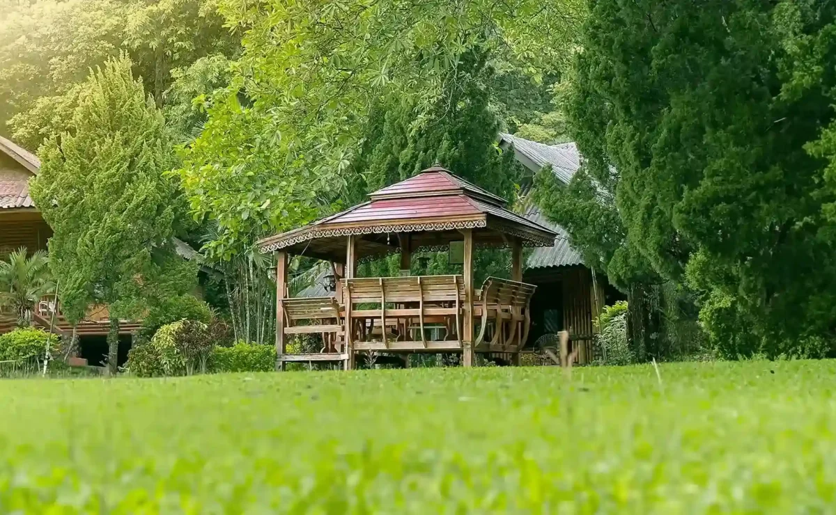 Wooden pavilion and lawn among the gardens at Siam Rehab in Chiang Rai