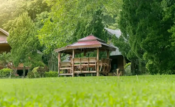Wooden pavilion and lawn among the gardens at Siam Rehab in Chiang Rai