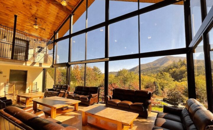 Communal lounge at Smoky Mountain Lodge with sofas and tall windows facing the mountains