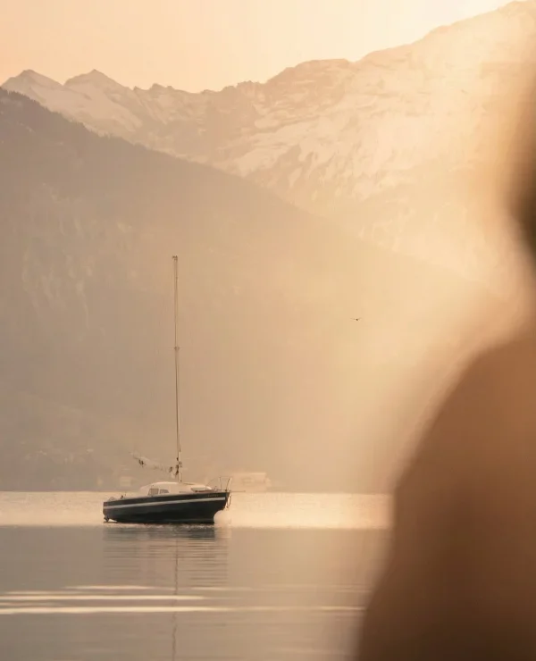 Sailboat on a lake with mountains beyond, pictured by The Kusnacht Practice