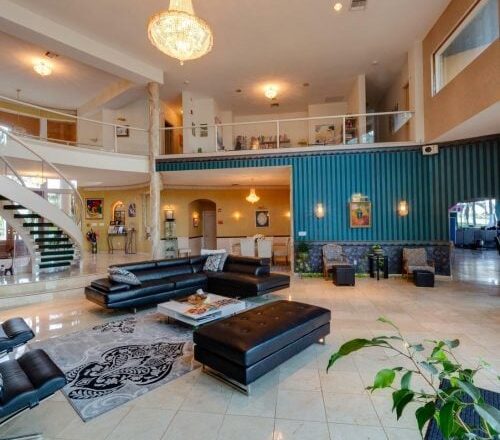 Double-height communal lounge with sofas at Tikvah Lake Recovery in Sebring