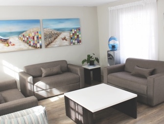 Sofas and coffee table in a communal lounge at Harmony Clinic in Hout Bay