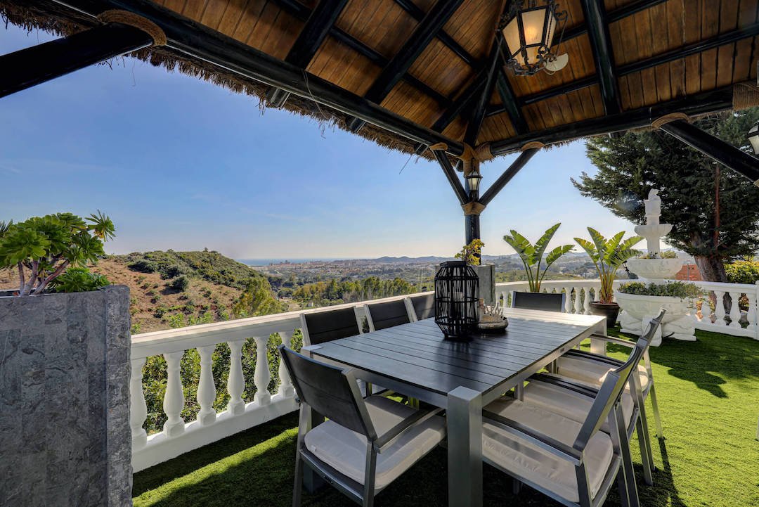 Covered outdoor seating with coastal views at Villa Paradiso Spain